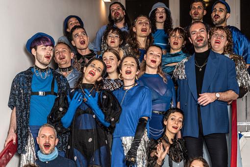 You can see the “Schmusechor”, women and men in black and blue robes and costumes, who have positioned themselves on the staircase