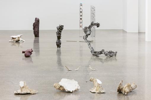 Exhibition view: Objects made of natural materials or as if taken from nature, scattered on the terrazzo floor