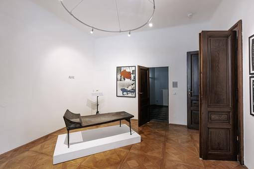 Photo of a room in the Sigmund Freud apartment in the center a couch made of dark brown wood on a white pedestal