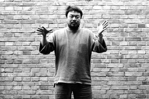 Portrait photo black and white of artist Ai Weiwei with outstretched arms