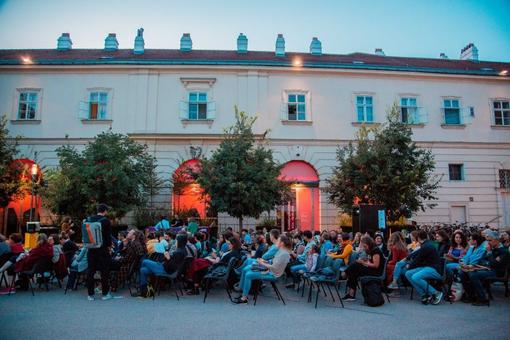 Scene in the courtyard in front of the Az W, looking into the audience waiting for the film screening.