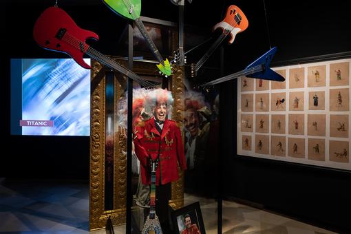 Ausstellungsansicht mit einer Installastion in der Mitte des Bildes, die den Sänger Falco als Amadeus umrahmt von Gitarren zeigt