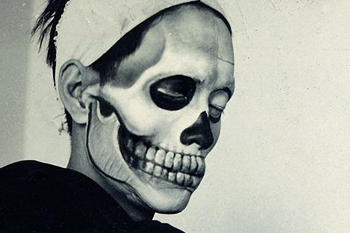 Black and white photo of head with lower jaw like skull, rest of face seems like black and white mask
