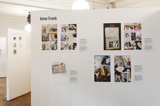 Foto einer Ausstellungsansicht, vergrößerte Comic-Ausschitte auf einer weißen Wand