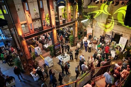 The photo offers a bird's eye view of part of the Gault & Millau gourmet fair at the Ottakringer brewery. Individual stands can be seen, the public strolls, tastes and savors