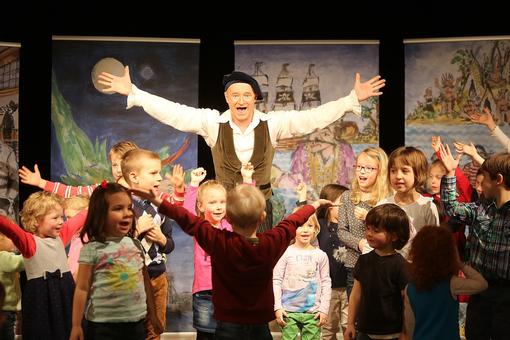 Der Schauspieler und Musiker Gernot Kranner während eines Kinderkonzertes mit vielen Kindern germeinsam auf der Bühne