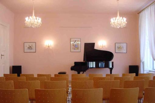 Photo of the lecture hall of the Society for Musical Theater with a grand piano and seating