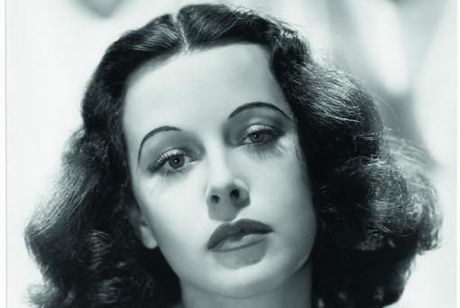 The portrait shot in black and white shows the actress Hedi Lamarr with shoulder-length dark brown hair