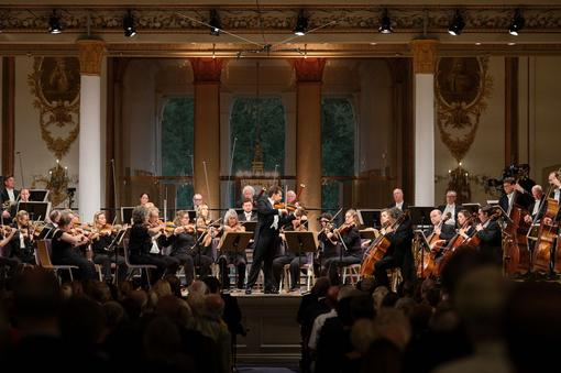 Photo of the Chamber Orchestra of Europe, in the middle the soloist and conductor Julian Rachlin playing the violin.