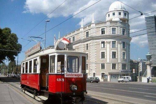 Das Foto zeigt eine historische Wiener Straßenbahn vor dem Gebäude der Urania
