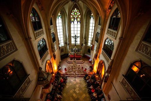 The photo shows the Gothic Hofburg Chapel, a view from the gallery down into the sanctuary