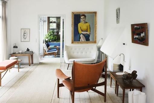Ansicht einer hellen Wohnung mit Gemälden an den weißen Wänden, geschmackvoll eingerichtet mit Designmöbeln