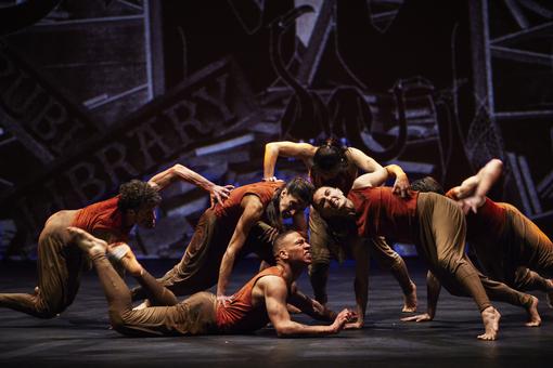Foto einer Tanzperformance  mit sechs Tänzern in rotbraunen Kostümen