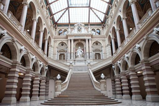 Interior view of the Vienna Palace of Justice: magnificent staircase, the statue of Justizia in the center, columned arcades to the left and right of the staircase