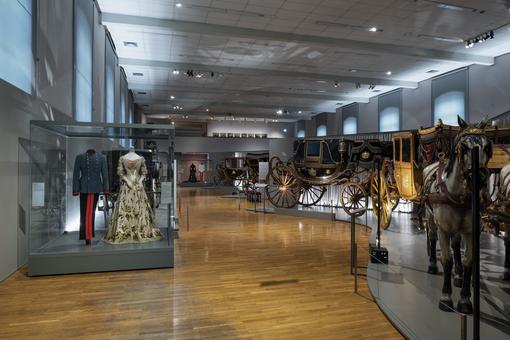 Interior view of the Imperial Carriage Museum with historical carriages, dresses and uniforms