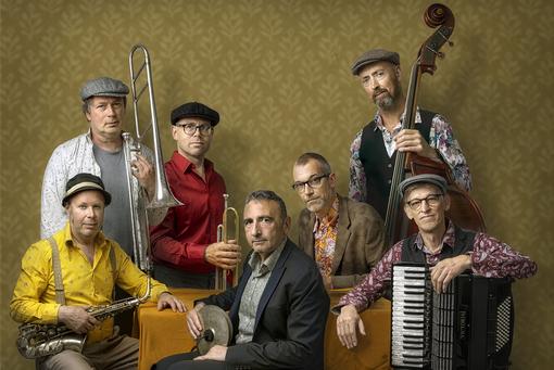 Klezmer band with seven members and their instruments in hands