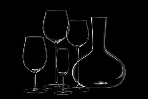 Ein Trinkservice mit Karaffe, Wasserglas, Likörglas, Weißwein- und Rotweinglas der Firma J. & L. Lobmeyr vor schwarzem Hintergrund