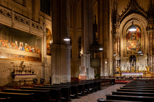 Das Foto zeigt den Innenraum der Minoritenkirche mit dem Hochaltar und dem Mosaik "Das letzte Abendmahl" nach Leonardo Da Vinci, alles in feierlicher Beleuchtung