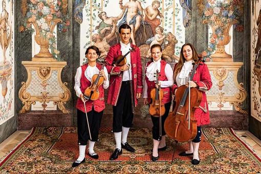 Die Mitglieder des Streichquartetts Mozart Ensembles Wien in historischen Kostümen vor den Fresken der Sala Terrena im Deutschordenshaus