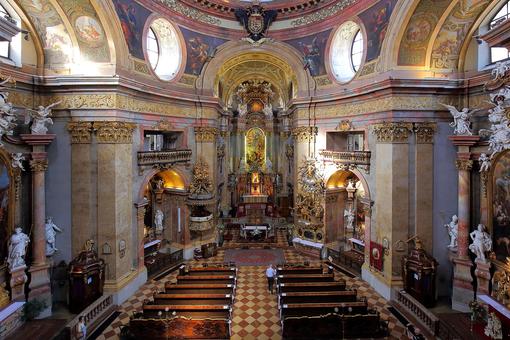 The photo shows an interior view of the baroque St. Peter's Church in Vienna with the high altar