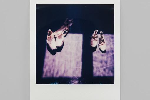 Zu sehen ist ein Polaroid-Foto, das zwei Paar rosa Ballettschuhe zeigt