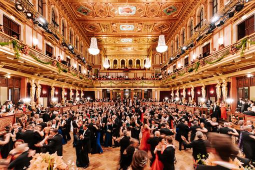 You can see the golden hall of the Musikverein, a festively dressed ball audience dancing