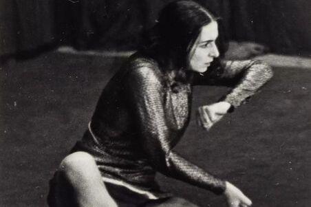 The black and white photo shows the dancer Rosalia Chladek, looking to the right, her arms in motion, her hands clenched into fists