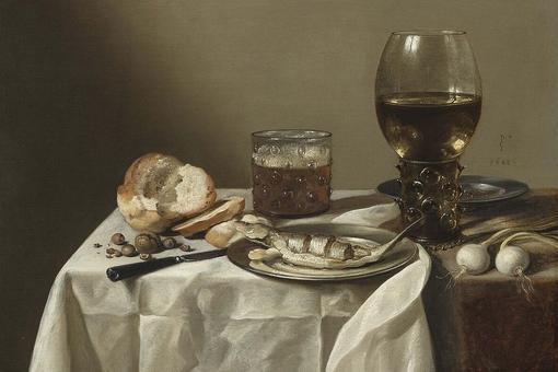 Das Foto zeigt ein Stillleben von Pieter Glaesz. Es zeigt ein Silberteller mit gebratenem Fisch, einen Glaspokal, ein Glas, Brot, ein Meser und zwei weiße Ziebeln auf einem weißen Tischtuch