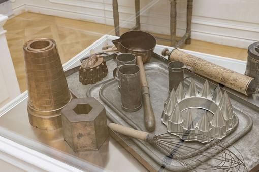 Photo of various kitchen utensils from the court kitchen of the time: cake pans, measuring cups, trays, whisks, etc.