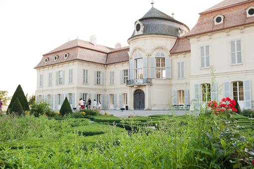Das Foto zeigt die Außenansicht des barocken Jagdschlosses Niederweiden, davor sieht man Teile des barocken Schlossgartens