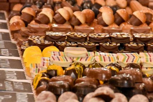 The photo shows various chocolate pralines in different shapes and colors