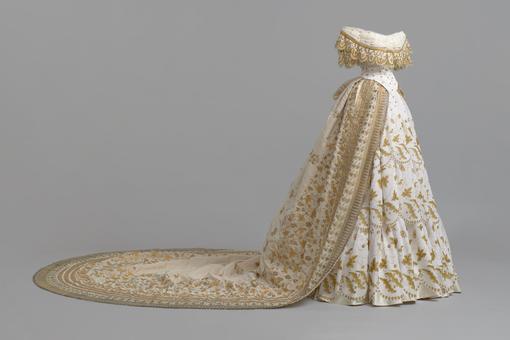 Photo of the original train and reconstruction of the ceremonial dress from the bridal trove of the future Empress Elisabeth of Austria. The dress is made in the colors white and gold.