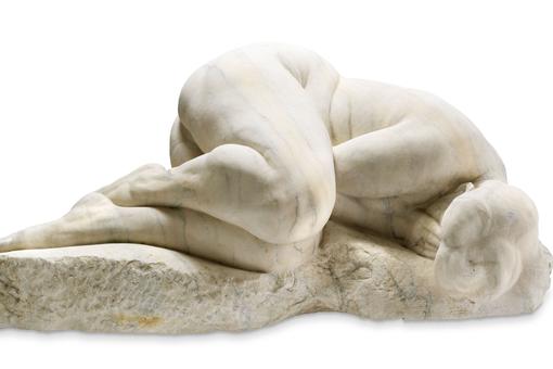 Photo of marble sculpture showing naked woman lying huddled on the ground