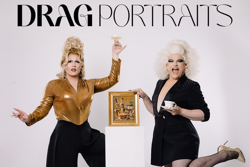 Zu sehen sind die beiden Dragqueens Grazia Patricia & Ryta Tale, die links und rechts neben einer Stele mit einem kleinen Gemälde stehen