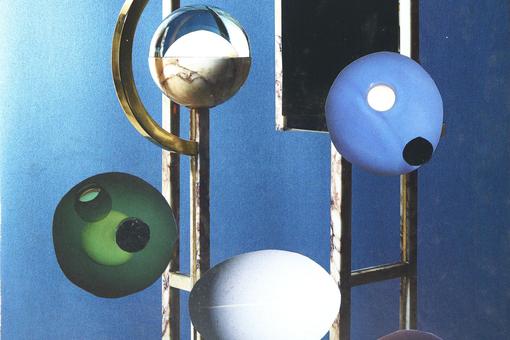 The image shows four spheres in white, green, blue and silver, a metal framework on which the sphere seem to be mounted, all against a blue background