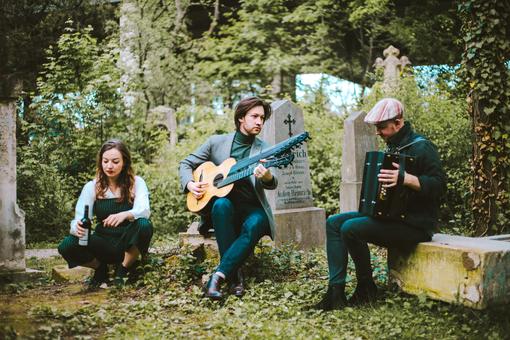 The photo shows the Viennese ensemble vorstadtkollektiv playing music in an overgrown cemetery