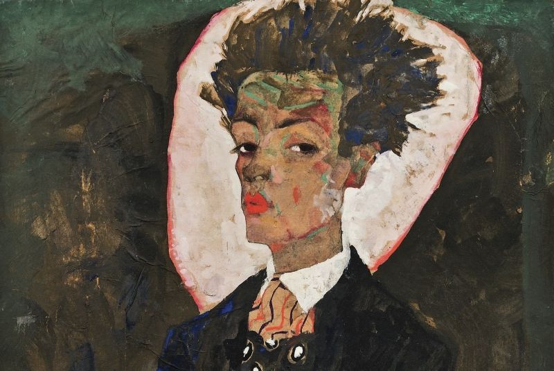 Ausschnitt aus: Egon Schiele, Selbstporträt mit Pfauenweste, 1911 © Ernst Ploil, Wien Das Bild zeigt einen Ausschnitt des Gemäldes "Egon Schiele, Selbstporträt mit Pfauenweste". Zu sehen ist der Kopf und die Schultern in Hemd und Anzug von Egon Schiele, hinter dem Kopf eine weiße Fläche wie ein Heiligenschein, sonst dunkler Hintergrund