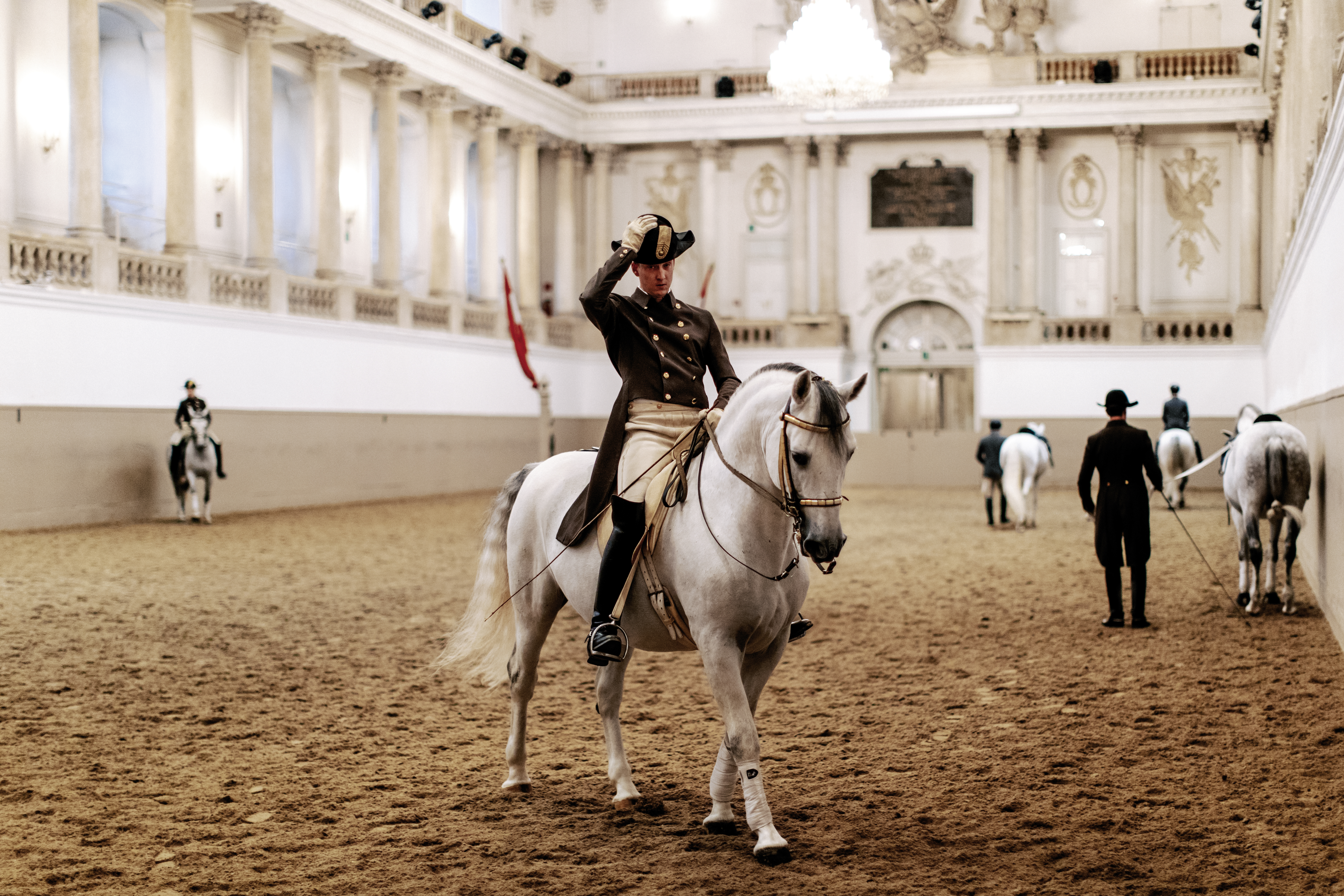 © WienTourismus / Paul Bauer The photo shows the famous Lipizzaner stallions with their riders during training in the Winter Riding School of the Spanish Riding School