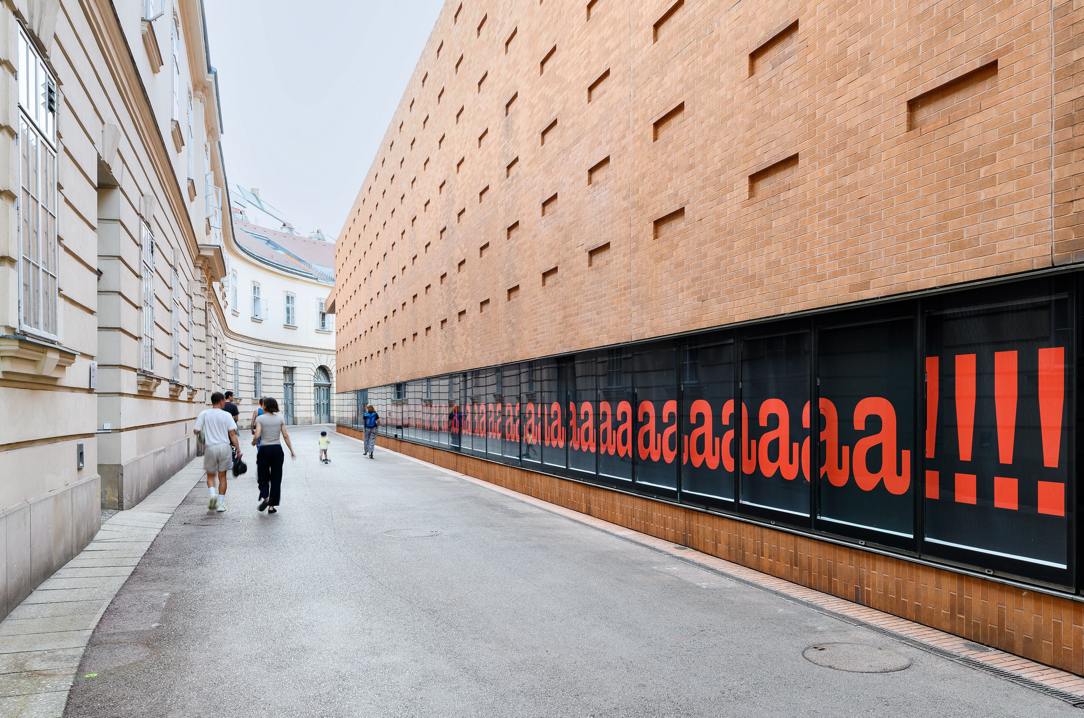 Nora Turato, Aaaaaaaaa....!!!, Kunsthalle Wien 2024, Courtesy die Künstlerin @ Foto: Iris Ranzinger Zu sehen ist Nora Turatos 62 Meter langes Wandbild an der südwestlichen Außenwand der Kunsthalle Wien, dies besteht aus unzähligen roten Buchstaben a und am Ende mit Rufzeichen auf dunklem Hintergrund