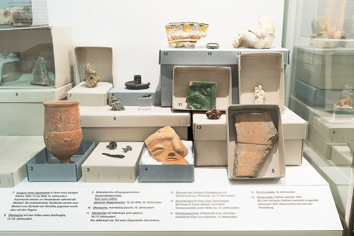 Römermuseum, Foto: Lisa Rastl © Wien Museum Photo with different archeological finds like clay vases, shards, figurines