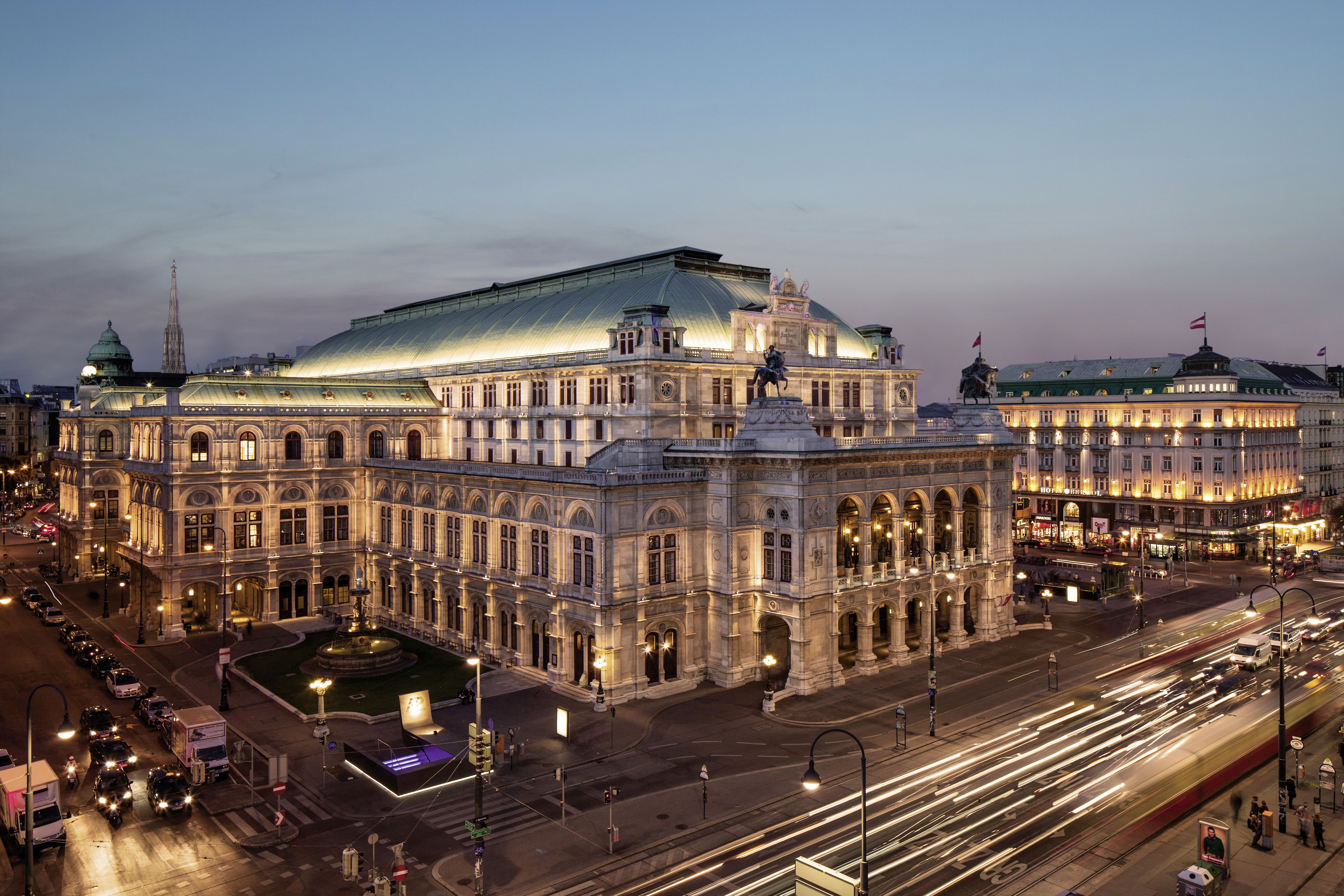 Wiener Staatsoper © WienTourismus/Christian Stemper Zu sehen ist das historische Gebäude der Wiener Staatsoper in abendlicher Beleuchtung, von einem Gebäude gegenüber vom Ring aus fotografiert
