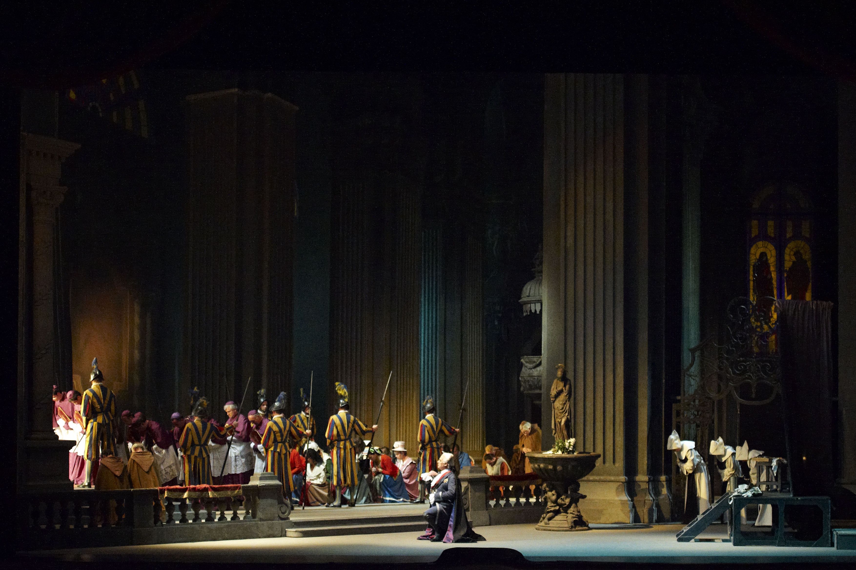 Wiener Staatsoper / Tosca @ Foto: Michael Poehn The scene photo shows a situation in St. Peter's Basilica, the Swiss Guard guarding a group of clergymen and women, in the foreground one of the main actors kneeling in front of this group