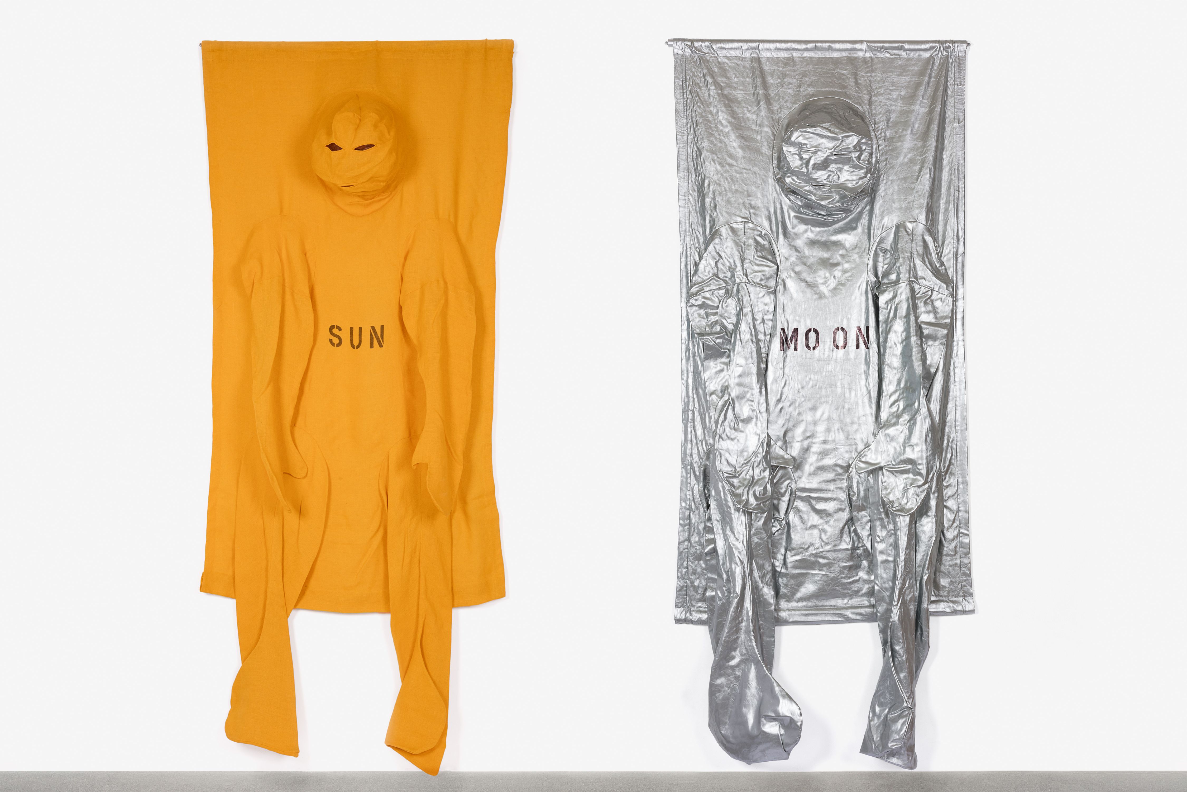 The photo shows two works by Nicola L., two suspended body covers, one sun-yellow for the sun, one silver-colored for the moon